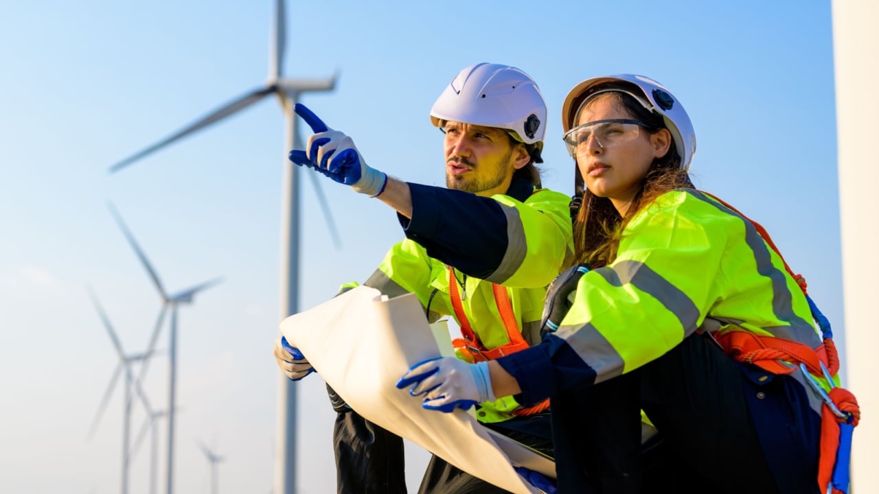 technician working outdoor at wind turbine field. Renewable energy engineer working on wind turbine projects, Environmental engineer research and develop approaches to providing clean energy sources