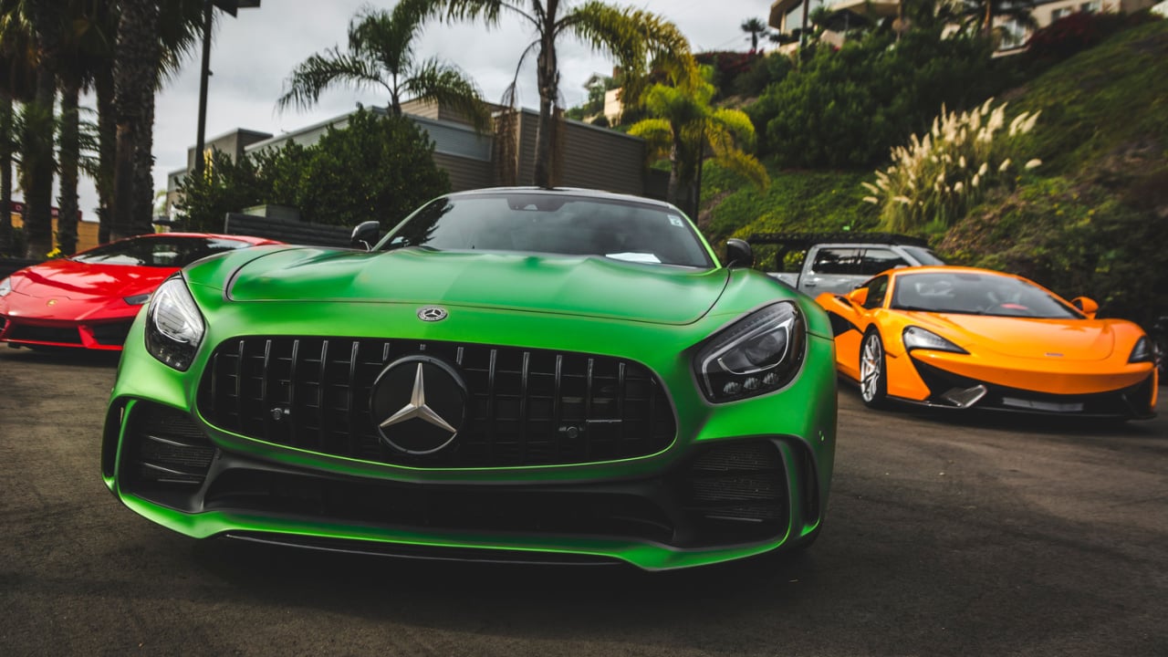 Front view of three supercars. green Mercedes-AMG GTR, red Lamborghini Huracan, orange McLaren. Beautiful Machines.