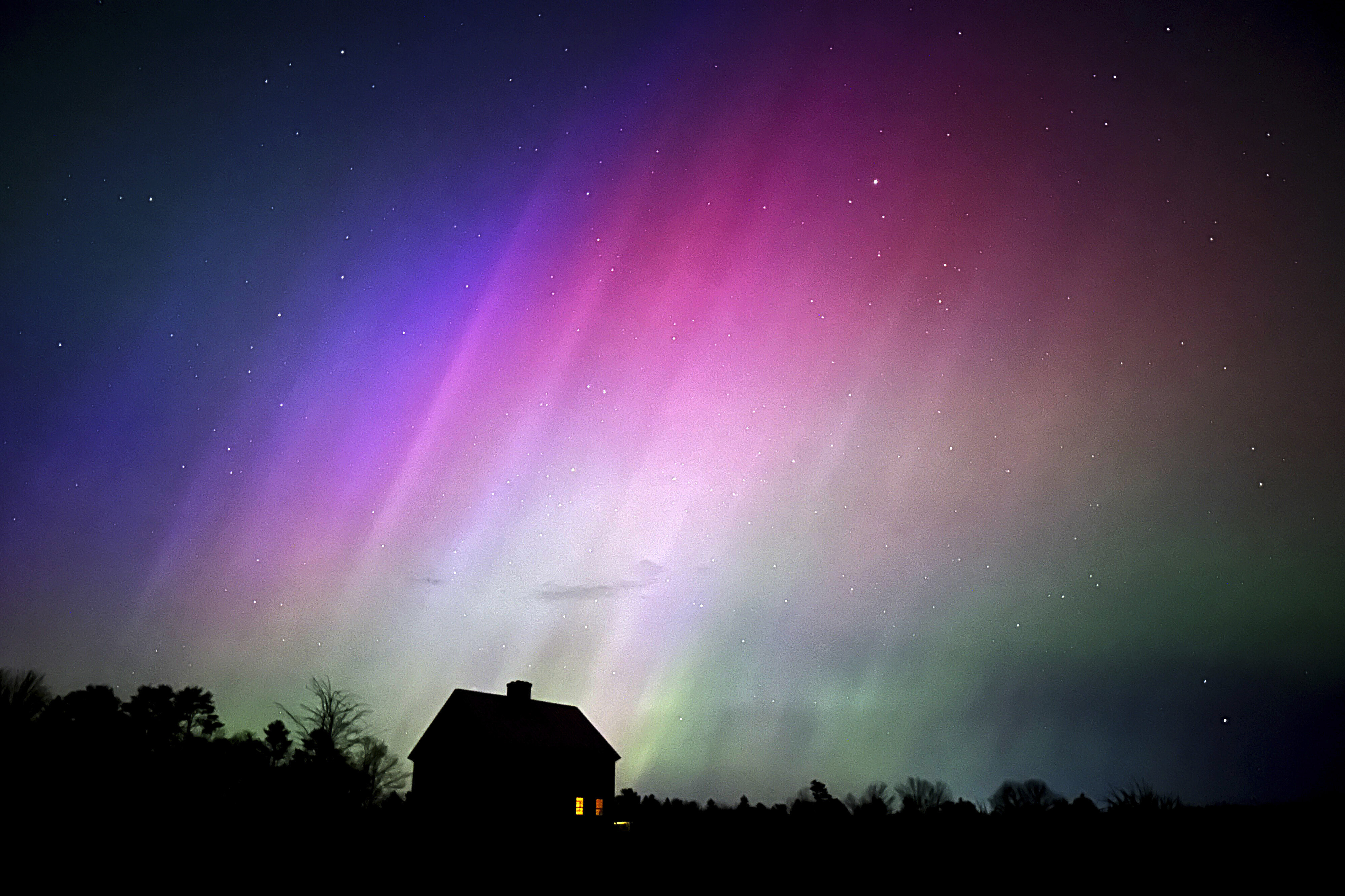 The northern lights flare in the sky over a farmhouse, late Friday, May 10, 2024, in Brunswick, Maine. 