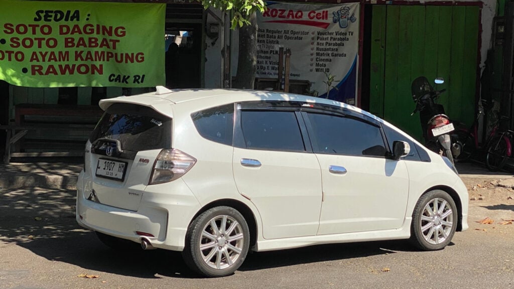 A white Honda Jazz 2013 is parked at the old Nganjuk terminal.