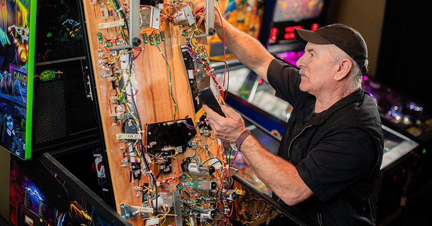Owner fixing a vintage pinball machine