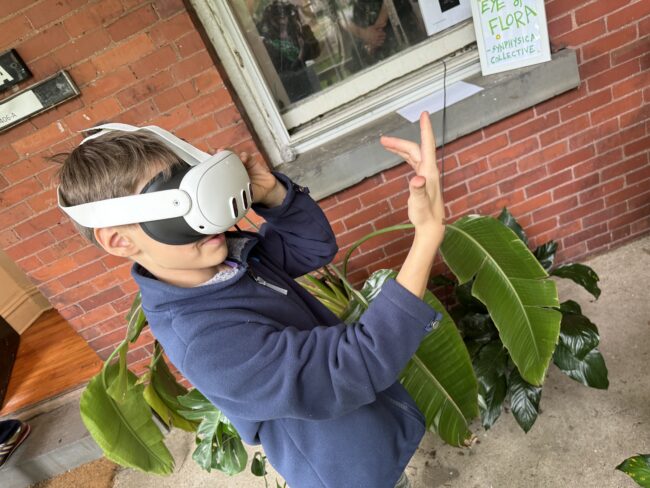 Boy wearing VR headset in front of building